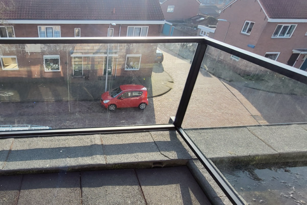 Glazen balustrade om dakterras in IJmuiden